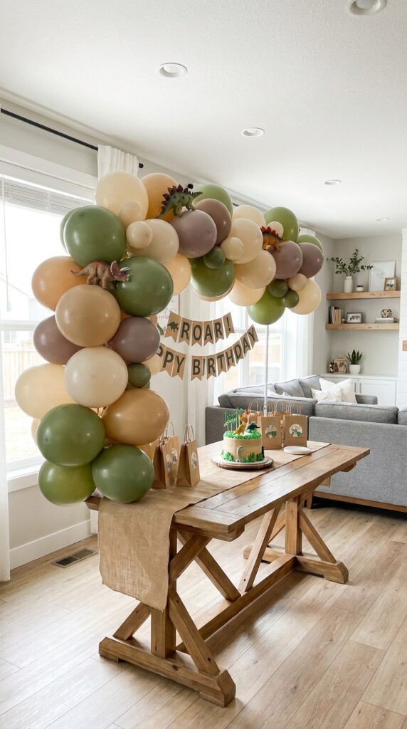 Green dinosaur-themed balloon garland setup for birthday party