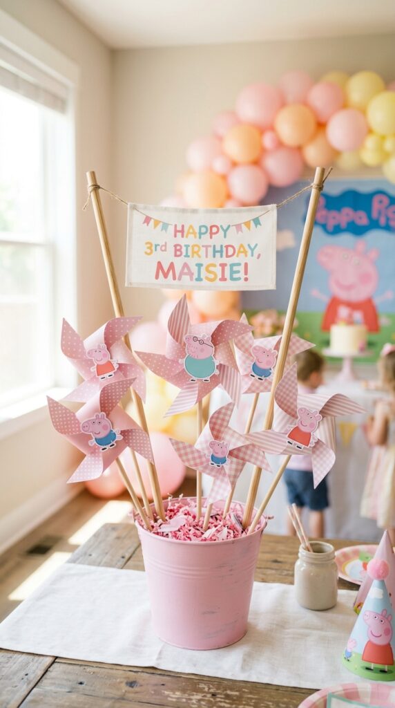 Peppa Pig pinwheel centerpiece in pink bucket with pastel paper pinwheels and character toppers for birthday party.