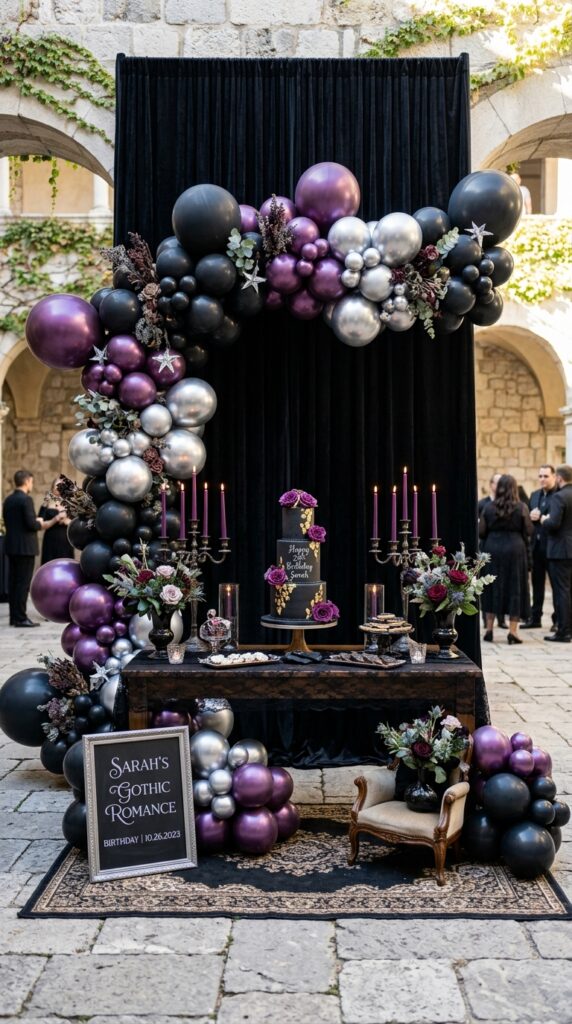 Black gothic birthday backdrop with balloon arch, candles, and dark elegant party decor.
