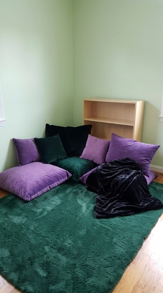 Cozy storybook reading area at a Wicked-themed kids birthday party.
